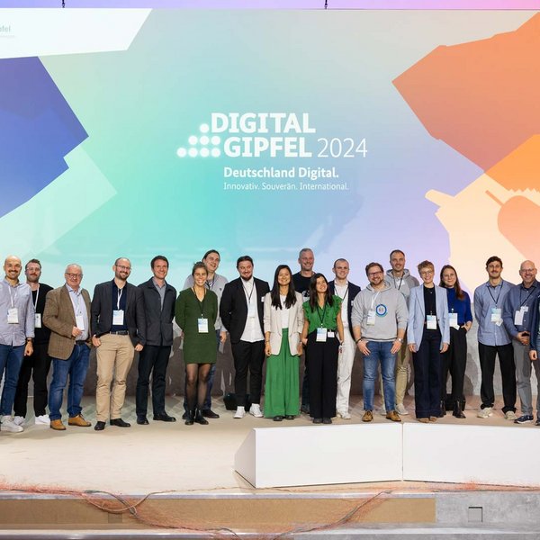 Gruppenfoto aller Projektteams auf der Bühne des Digital-Gipfels 2024.