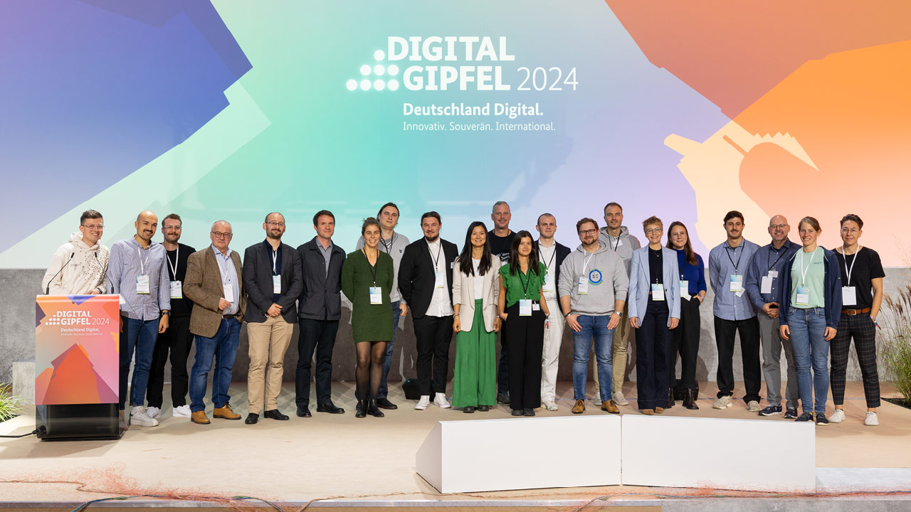 Gruppenfoto aller Projektteams auf der Bühne des Digital-Gipfels 2024.