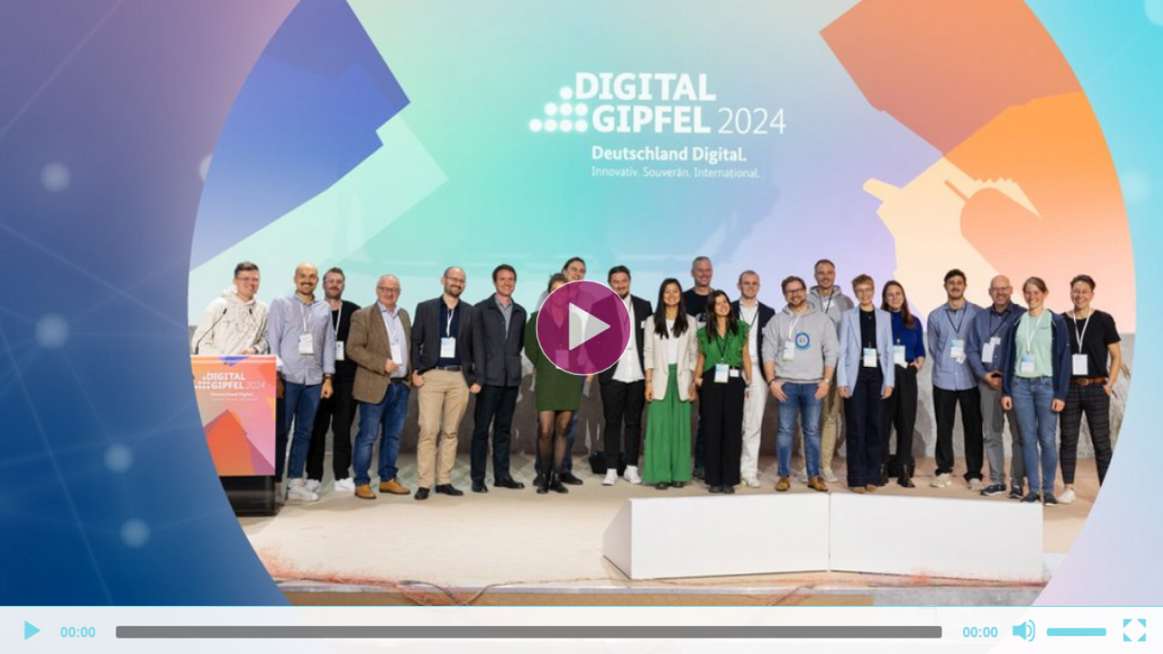 Gruppenfoto aller Projektteams auf der Bühne des Digital-Gipfels 2024. In der Mitte befindet sich eine Wiedergabetaste, die anzeigt, dass es sich um ein Video-Thumbnail handelt.