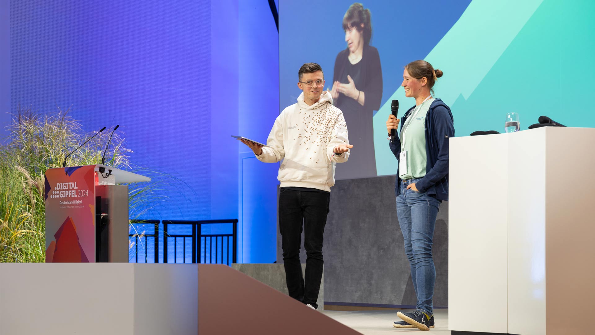 Jacob Beautemps mit Lena Trautmann pitchen ihr KI-Projekt auf der Bühne des Digital-Gipfels 2024.